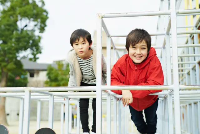 インター校の校庭の遊具で遊ぶ男の子たち