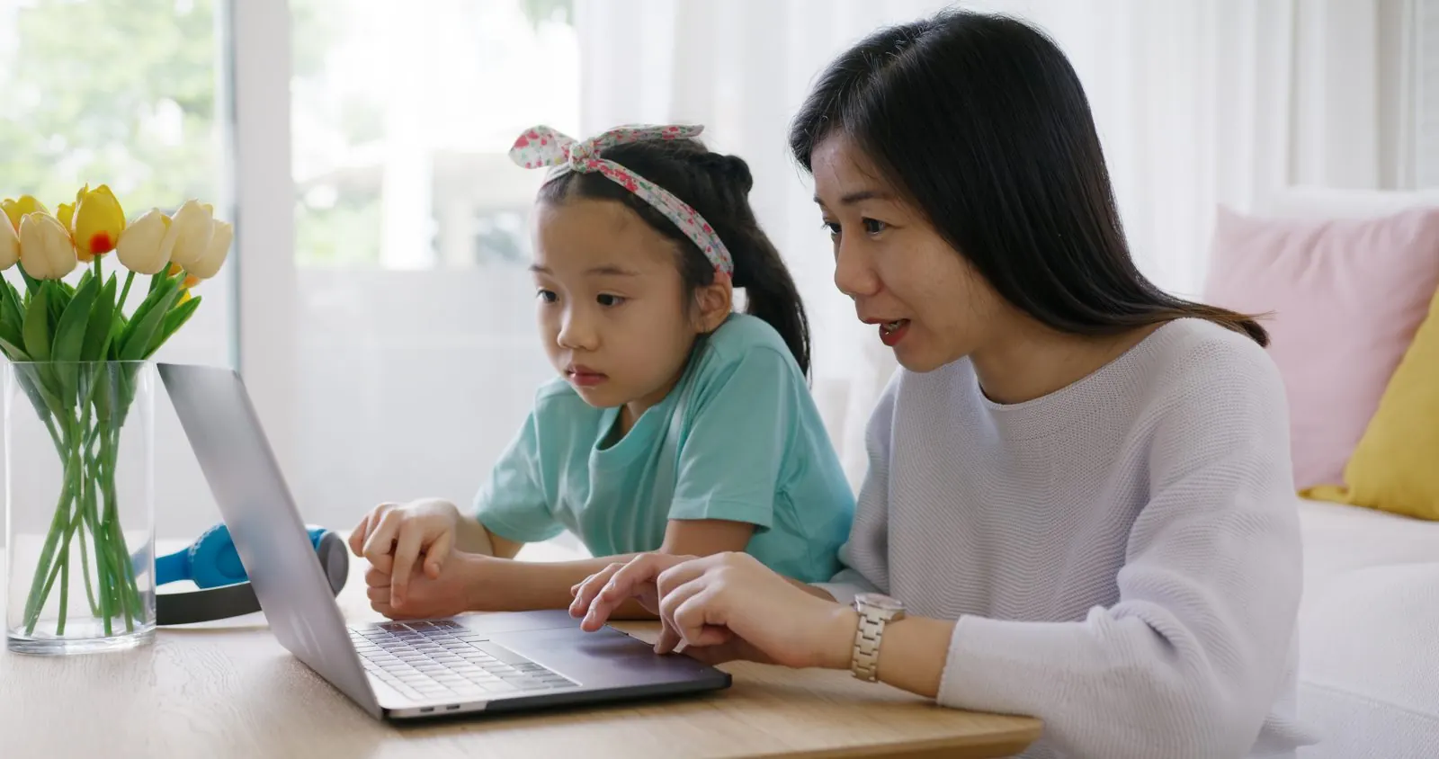 ノートパソコンで学校の情報を一緒に見る母親と娘