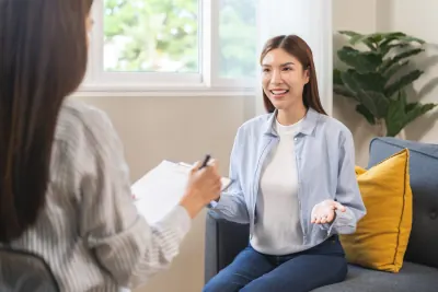 ソファで担当者に話をする母親
