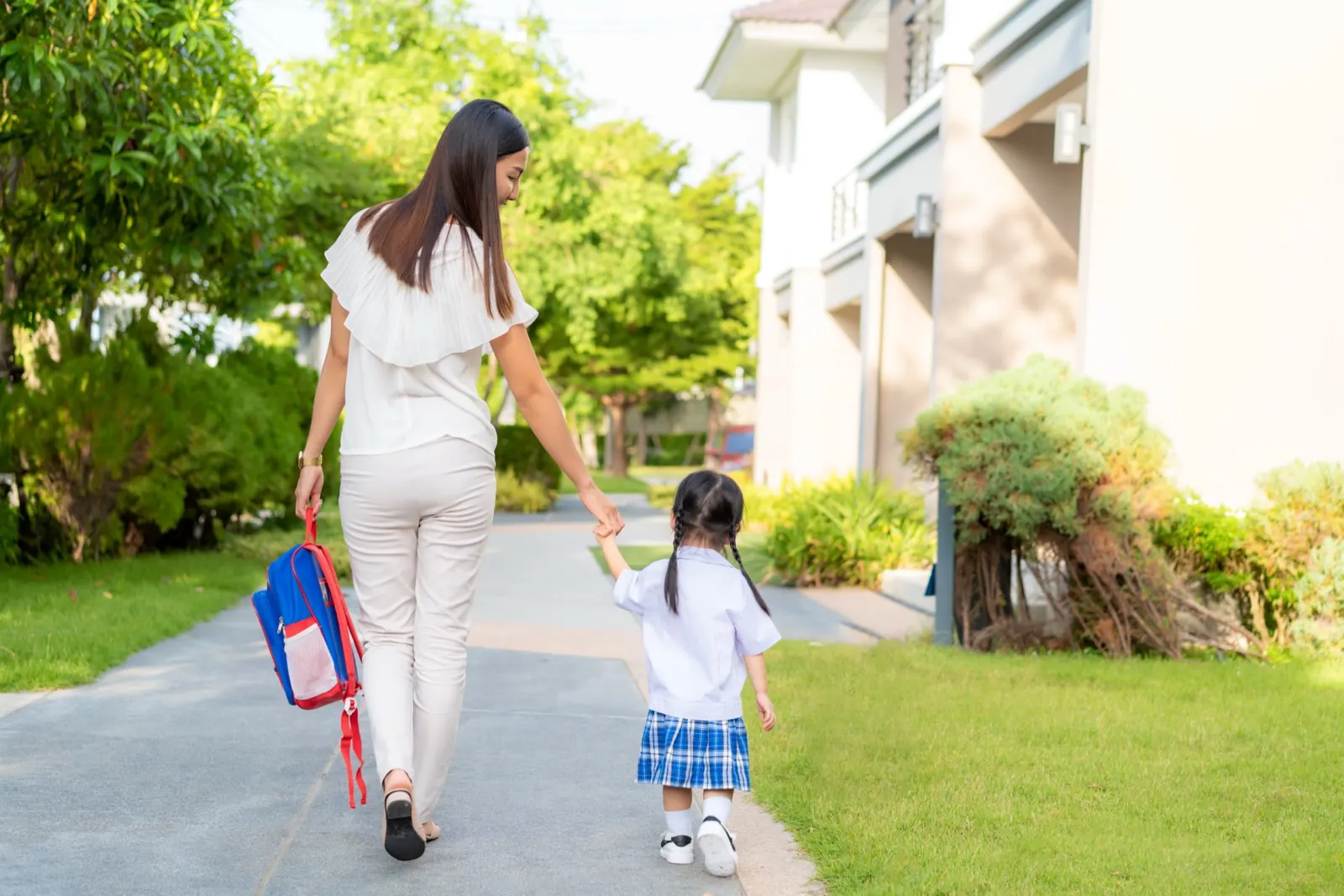 制服の娘の手を引いて学校へ向かう母親